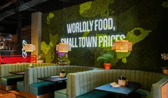 Restaurant met zitbanken voor een groene mooswand